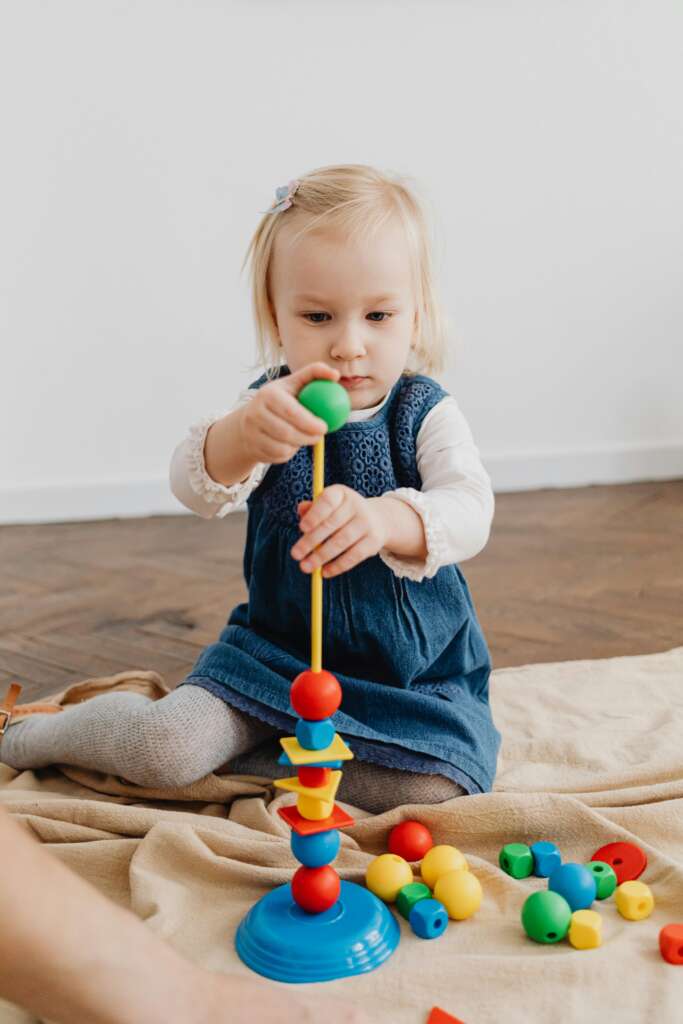 toddler girl playing with building blocks
